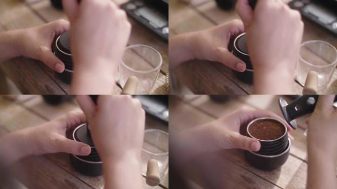 有人在Portafilter (浓缩咖啡机) 中夯实 (压制) 咖啡渣的特写镜头