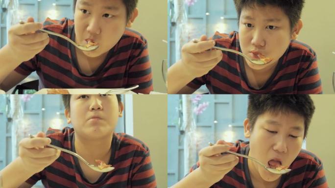 快乐的亚洲男孩在度假旅行期间与家人、生活方式理念在酒店自助餐厅附近享用早餐。