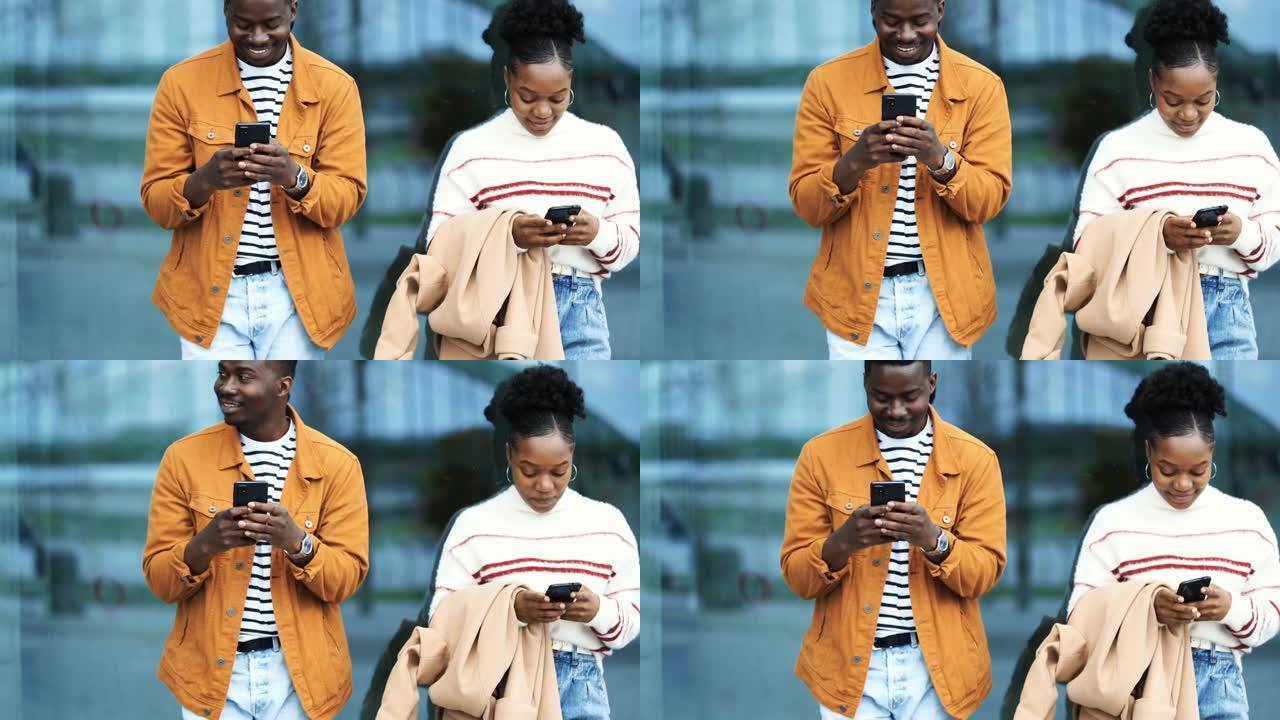 年轻的美国黑人夫妇在城市街道上使用手机。