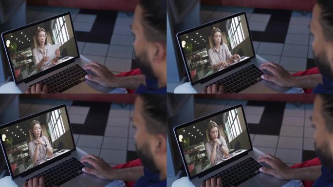 中东男子在笔记本电脑上与女同事进行视频通话