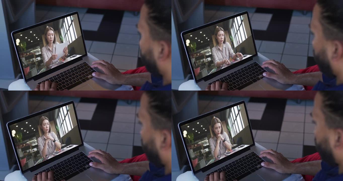 中东男子在笔记本电脑上与女同事进行视频通话