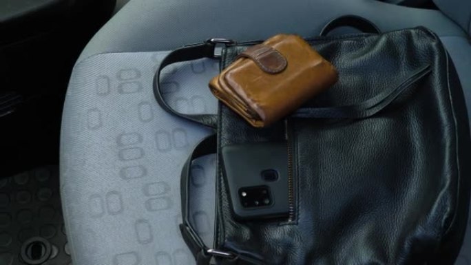手提包和钱包从汽车座椅上被盗的高角度平移镜头