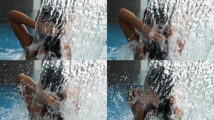 特写的年轻女子在水疗酒店的游泳池里接受水疗。美丽的女孩用水力按摩放松