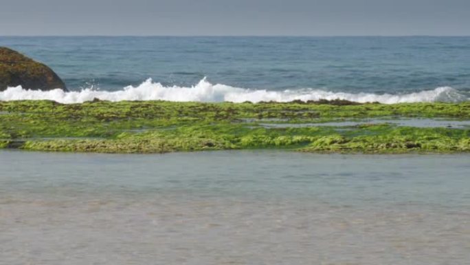 棕色石头和海洋海岸附近无边无际的蓝色海浪