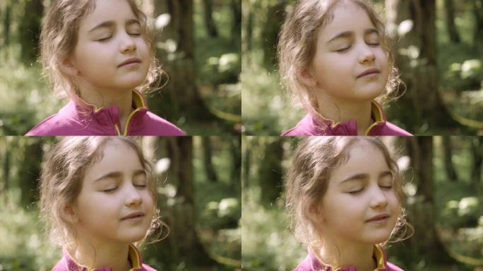肖像儿童女孩呼出新鲜空气，深呼吸，减轻森林压力。梦幻般的平静轻松微笑的小女孩呼吸新鲜空气自然，宁静的