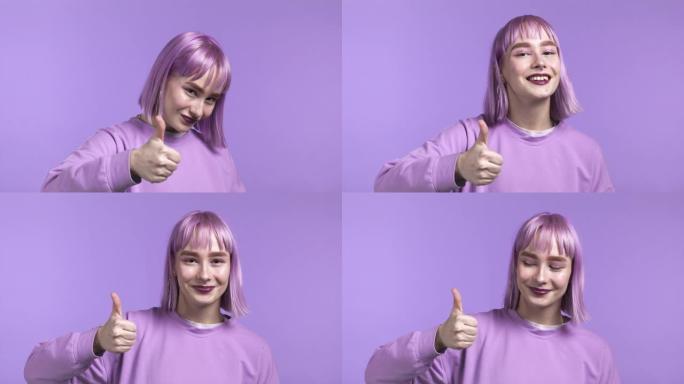 漂亮的女人露出拇指，就像在紫罗兰工作室背景上签名一样。染成紫色头发的积极年轻女孩对镜头微笑。赢家。成