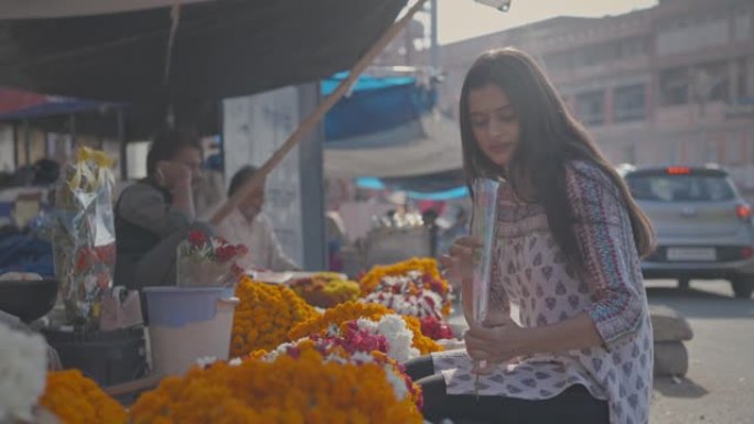 一位年轻的印度亚裔女性穿着传统的salwar kameez买花