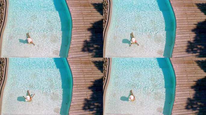 无忧无虑的女人在游泳池放松的视野。
