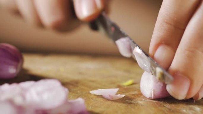 厨师在木板上切碎葱。特写。在微距拍摄中准备烹饪。传统泰国配料。