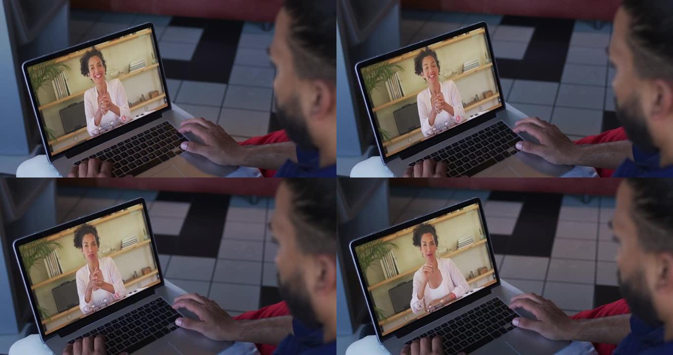 中东男子在笔记本电脑上与女办公室同事进行视频通话