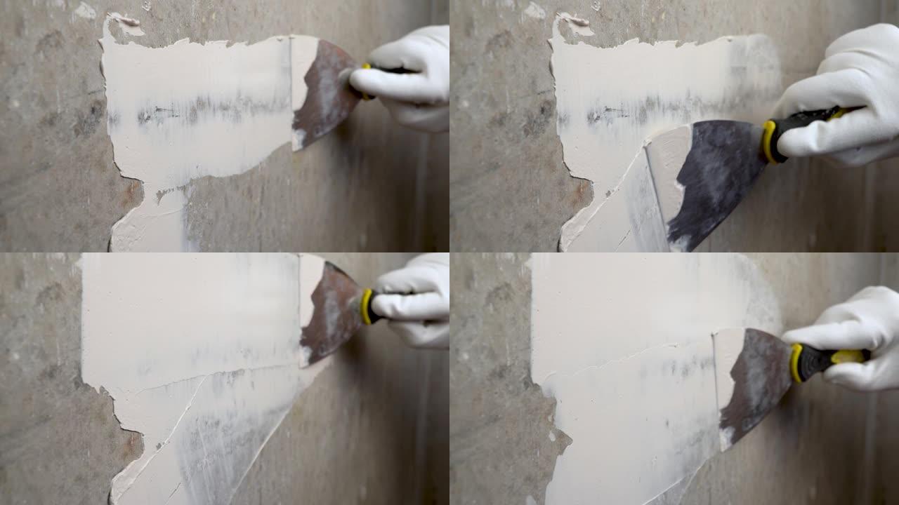 用聚合物腻子涂覆混凝土墙。抹灰工工作。公寓的装修。师傅用抹刀的工作。