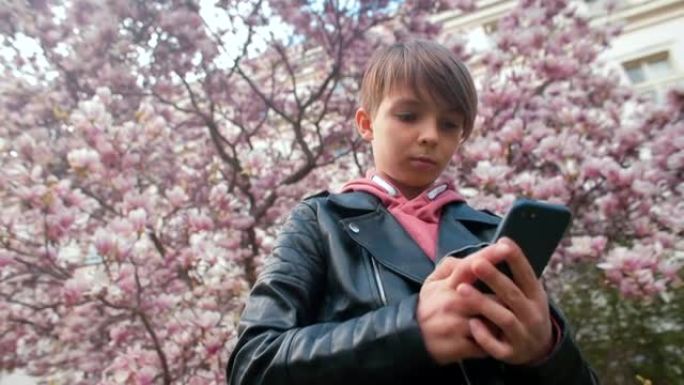 少年少年用手中的手机。拨号盘号码，放设备耳朵。