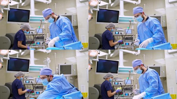 现代医院的医生和护士。穿着防护服的医务人员在手术前准备手术工具。现代化手术室。