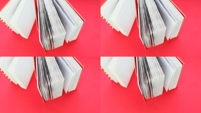 阅读书籍和文学。书页close-up.Learning和知识概念。红色背景上有红色封面的书