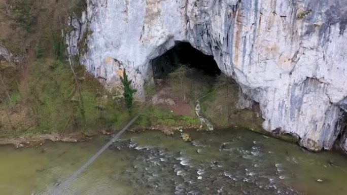 罗马尼亚Suncuius，Unguru Mare cave，无人驾驶飞机对大洞穴入口和野山河的鸟瞰图