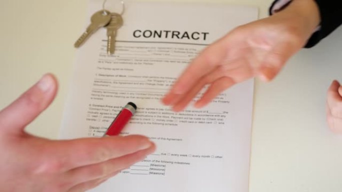 一个男人和一个女人握手，缔结成功的合同协议。买房子。