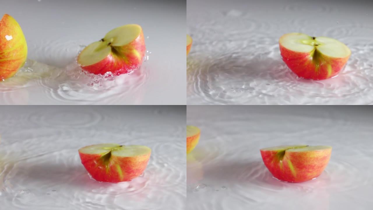 苹果落在桌子上，上面铺着一层薄薄的水。慢动作