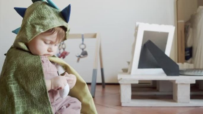 一个可爱的男婴在家里玩耍，穿着龙嘉年华服装-慢镜头视频