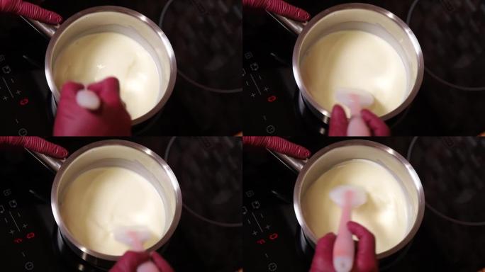 女人在做蛋糕奶油。在家制作传统巧克力自制蛋糕的过程。女人融化巧克力的特写镜头