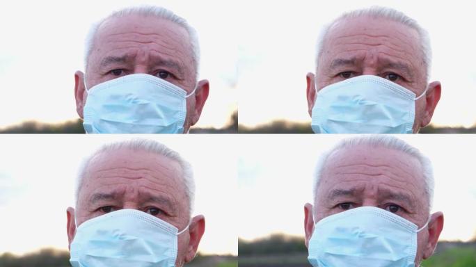一个戴着医用口罩的老人看着相机。