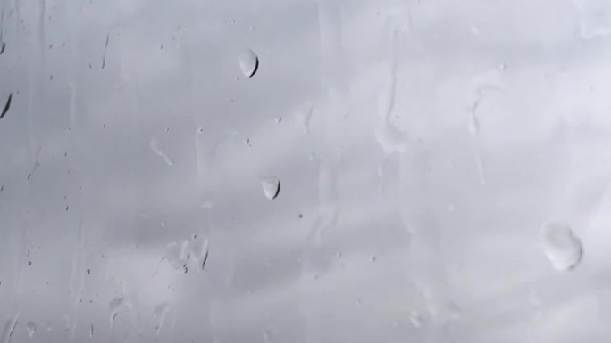灰云背景下雨湿玻璃的延时
