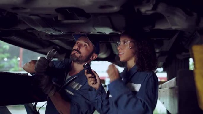 在汽车服务中从事汽车工作的机械师男人和女人。