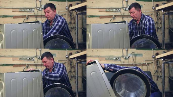 一名男性专家拆卸洗衣机