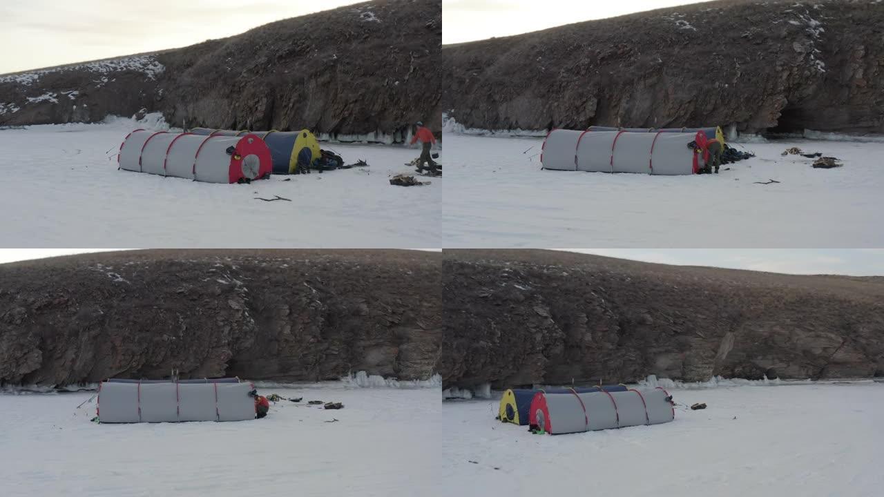 两个可容纳16人的大帐篷站在岩石岸边结冰的贝加尔湖的雪中