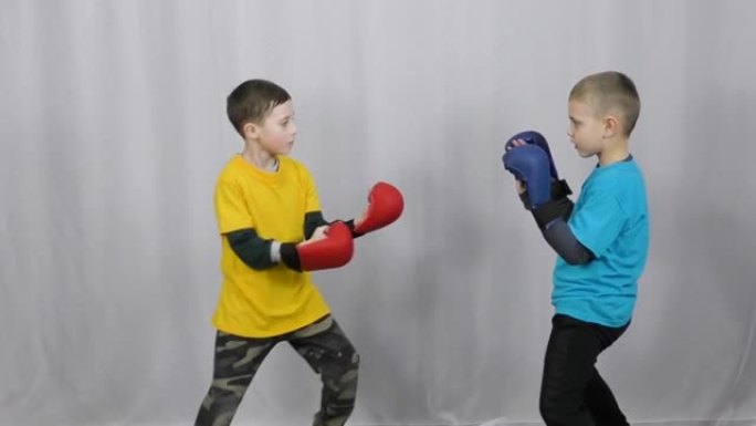 穿着黄色和蓝色t恤和手臂上的多色护垫的运动员在护垫上练习打拳
