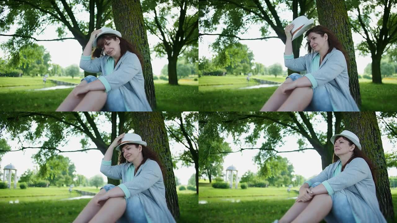 快乐的女人坐在公园里做梦，心寒，思考，记得一些美好的事情，好心情