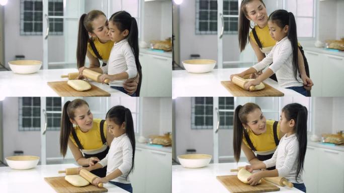母亲教小女儿如何在厨房里做面团或蛋糕
