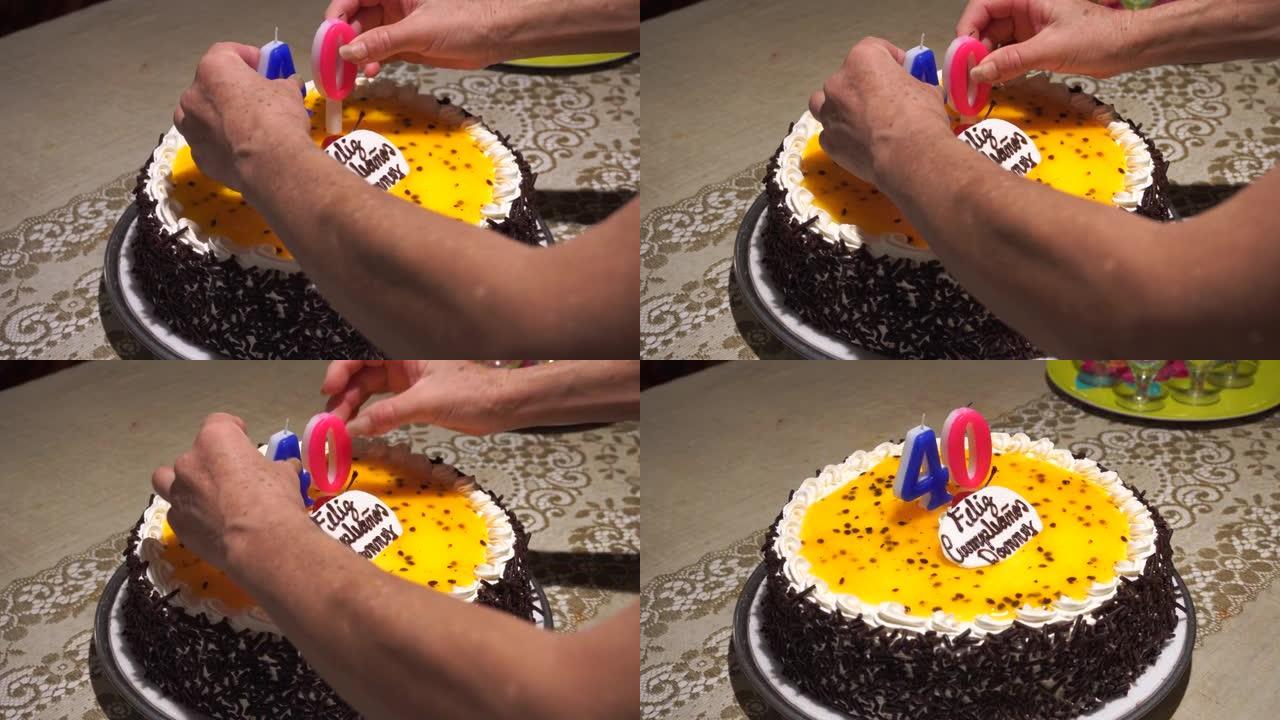 特写用手把两个40岁的蜡烛放在蛋糕上。