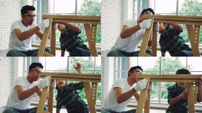 亚洲男人和儿子正在帮助组装房子里的橱柜。