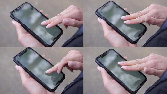 女人在智能手机上看卡片。用手指放大位置