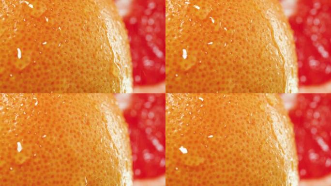 新鲜成熟橘皮的水滴下落和滚动的慢动作。有机食品和健康营养的完美抽象镜头。柑橘类水果的特写