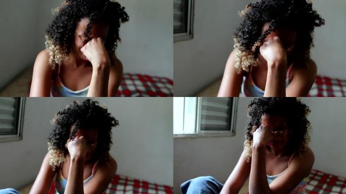 悲伤流泪的西班牙裔妇女独自在家里的床上哭泣。巴西女孩哭了