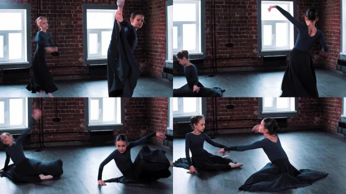 两个小芭蕾舞女演员在训练中穿着深色长裙跳舞