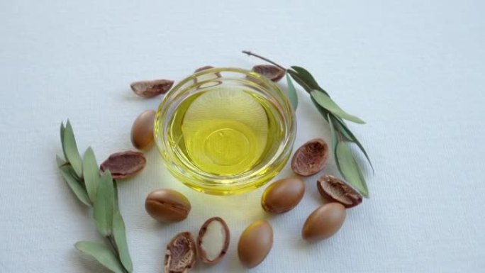 白色背景上的摩洛哥坚果油和种子。基于摩洛哥坚果油的化妆品概念