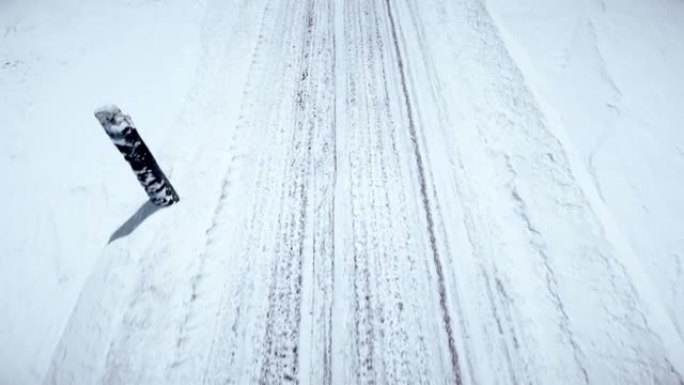 在积雪覆盖的山路的路面上，轮胎痕迹的鸟瞰图