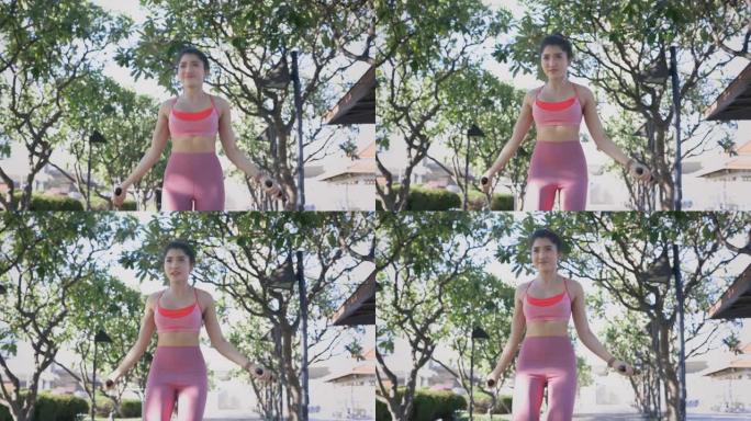 适合亚洲女性练习有氧运动，用跳绳减肥。年轻女子在公园跳绳。4k高质量镜头