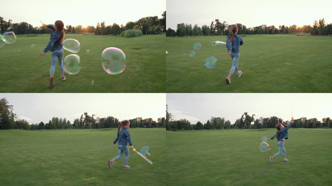无忧无虑的小女孩吹肥皂泡，玩得开心，日落时独自在绿野玩耍