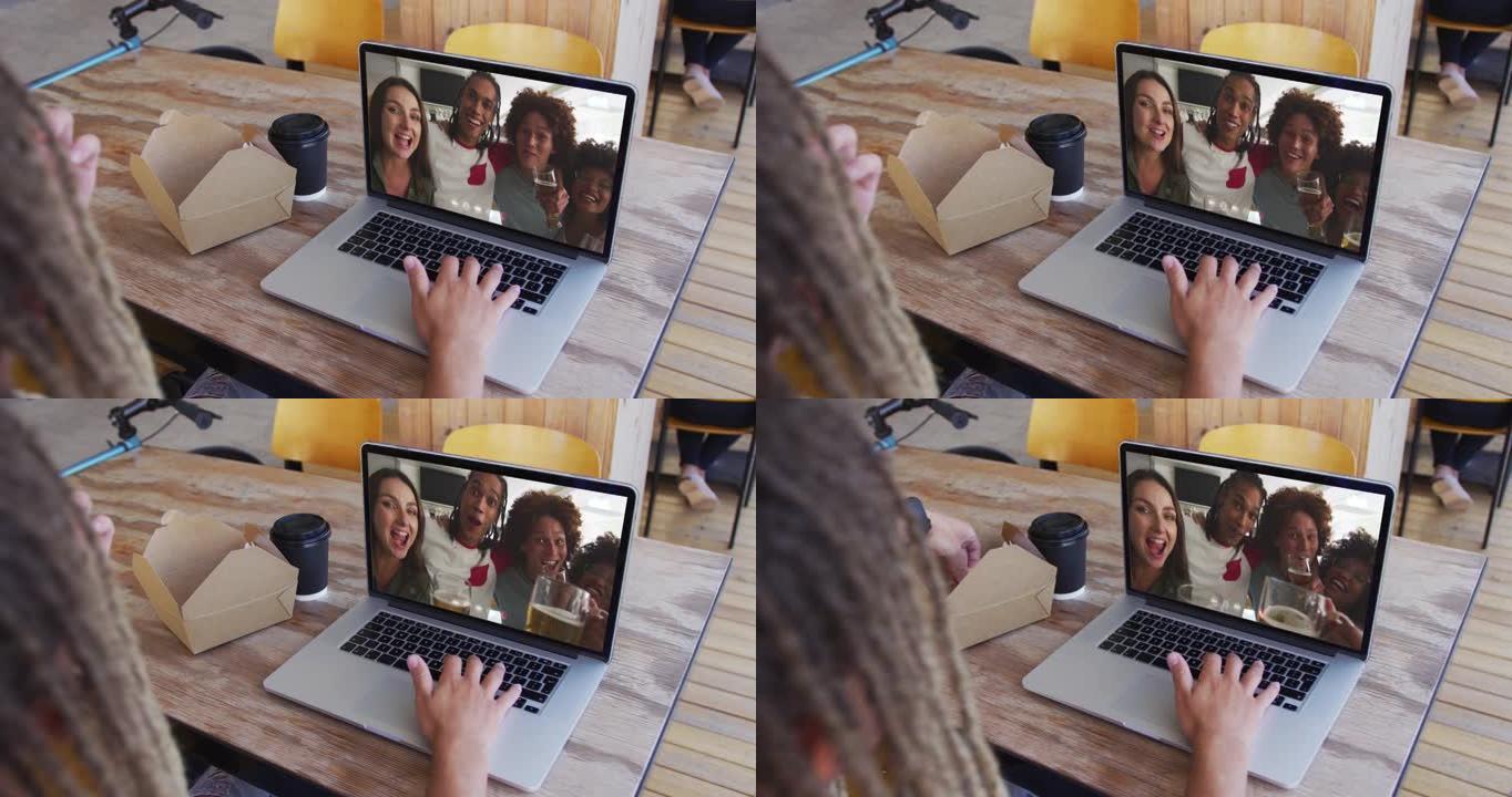 女人在咖啡馆用笔记本电脑进行视频通话时吃零食