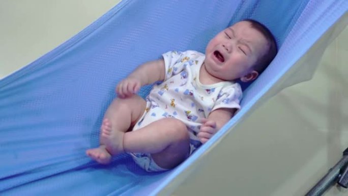 一个男孩在婴儿床上哭泣