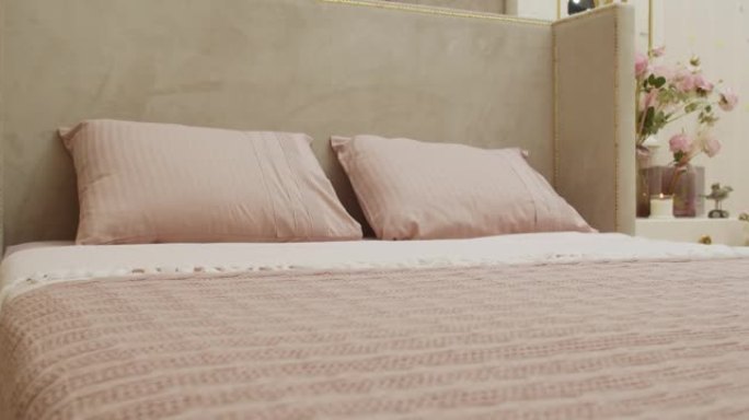 奶油-粉色枕头和同样颜色的纺织品封面的特写镜头