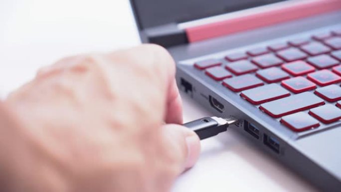 钥匙和u盘类型C进入白色背景的笔记本电脑。数据安全概念的加密和保护。