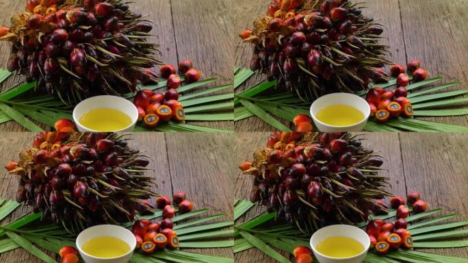新鲜油棕榈果和烹饪棕榈油在木质背景的棕榈叶上。