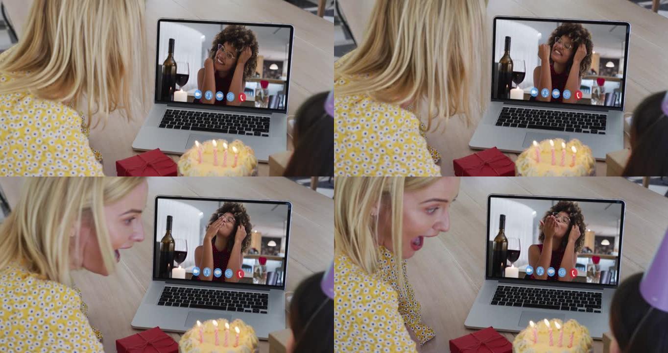 白人母亲和女儿坐在餐桌旁，使用笔记本电脑进行生日视频通话