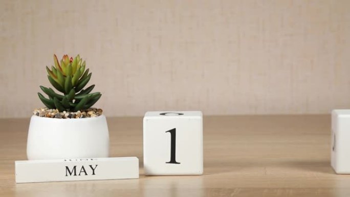 木制日历对5月12日来说是一个重要的事件，女人的手在日历上设置日期。春季。
