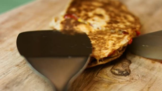 在木制切菜板上切一只新鲜油炸的鸡肉玉米饼。制作墨西哥玉米饼的过程