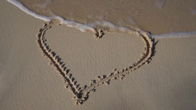 波浪来了，抹去了沙子里哈特的画。关系和团结的概念